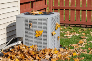 Outdoor HVAC system with fall leaves around it.